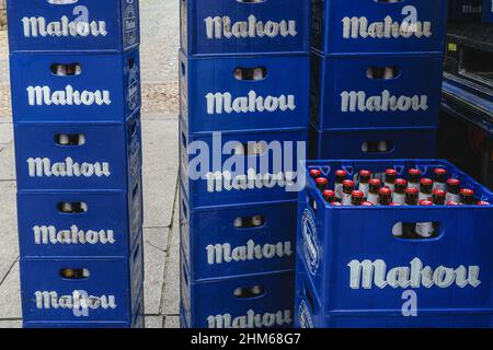 Blaue Kästen mit Bierflaschen der Marke Mahon auf dem Boden gestapelt. Stockfoto