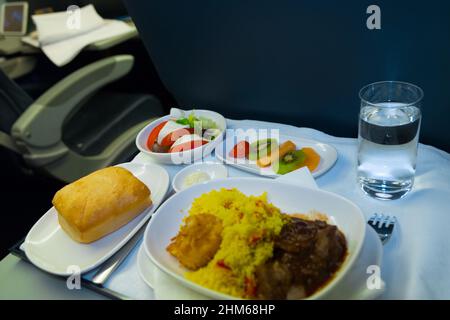 Essen an Bord der Business Class Flugzeug auf dem Tisch. Tablett mit Essen im Flugzeug. Fach von Lebensmitteln auf der Ebene, die Reise in der Business Class. Das Essen im Flugzeug Stockfoto