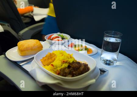 Essen an Bord der Business Class Flugzeug auf dem Tisch. Tablett mit Essen im Flugzeug. Fach von Lebensmitteln auf der Ebene, die Reise in der Business Class. Das Essen im Flugzeug Stockfoto