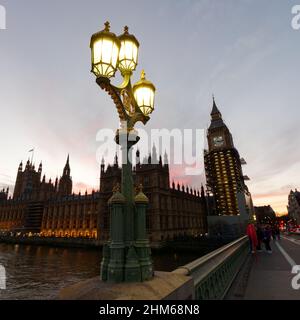 Street Lamp auf der Westminster Bridge bei Sonnenuntergang im Winter. Häuser des Parlaments hinter dem Elizabeth Tower mit Big Ben. Stockfoto