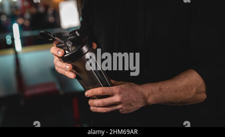 Nahaufnahme des mittleren Abschnitts eines unbekannten kaukasischen Mannes mit dunklem Supplement-Shaker Stockfoto