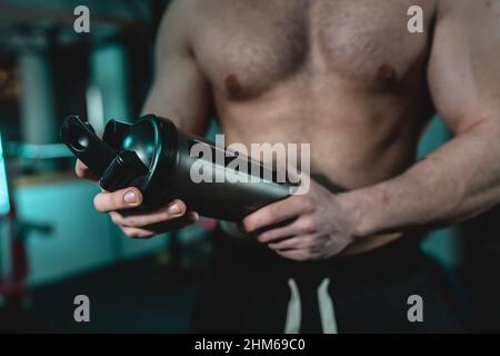Nahaufnahme des mittleren Abschnitts eines unbekannten kaukasischen Mannes mit dunklem Supplement-Shaker Stockfoto