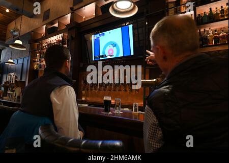 New York, USA. 07th. Februar 2022. Besucher sitzen an der Bar und sehen sich die Übertragung des Curling-Wettbewerbs während der Olympischen Winterspiele 2022 in Peking am 7. Februar 2022 in der Elgin Cocktail Bar in New York, NY, an. Die Olympischen Winterspiele 2022 werden vom 4th. Bis zum 20th. Februar in Peking, China, abgehalten und werden von bing im NBC/Peacock-Netzwerk ausgestrahlt. (Foto von Anthony Behar/Sipa USA) Quelle: SIPA USA/Alamy Live News Stockfoto