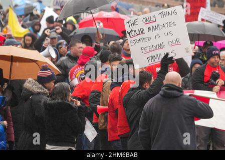 New York City, Usa. 07th. Februar 2022. Ein Protestler hält ein Plakat während des Protestes.über 300 Stadtarbeiter und andere marschierten heute über die Brooklyn Bridge aus Protest gegen die Ankündigung der Stadt, dass kommunale Mitarbeiter ohne Covid-19-Impfung bis zum Ende der Woche entlassen würden. Quelle: SOPA Images Limited/Alamy Live News Stockfoto