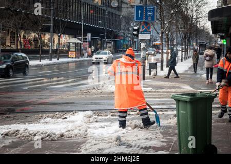 Selektive Unschärfen auf Mitarbeiter der gradska cistoca, der Reinigungsfirma von belgrad, Serbien, die während des Schneefals mit einem Showel Schnee bearbeiteten und räumten Stockfoto