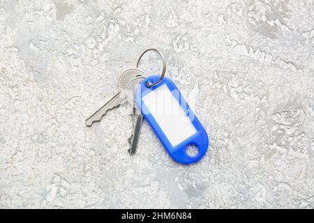 Schlüssel mit Plastiktag auf hellem Hintergrund Stockfoto