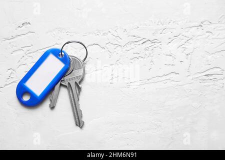 Schlüssel mit Plastiktag auf hellem Hintergrund Stockfoto