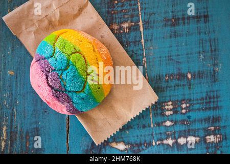 Regenbogen-Concha mit einem Herzen. Mexikanisches süßes Brot mit Regenbogendecke. Stockfoto