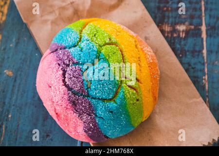 Regenbogen-Concha mit einem Herzen. Mexikanisches süßes Brot mit Regenbogendecke. Stockfoto