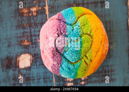 Regenbogen-Concha mit einem Herzen. Mexikanisches süßes Brot mit Regenbogendecke. Stockfoto