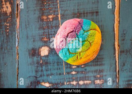 Regenbogen-Concha mit einem Herzen. Mexikanisches süßes Brot mit Regenbogendecke. Stockfoto