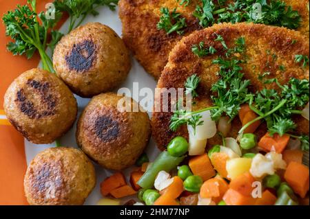 Rottweil, Deutschland. 07th. Februar 2022. Vegane Falafel, vegane Koteletts und Gemüse sind auf einem Teller in einer Küche zu sehen. Kredit: Silas Stein/dpa/Alamy Live Nachrichten Stockfoto
