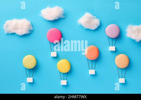 Makronen oder Makronen und Zuckerwürfel in Form von Heißluftballons, die am Himmel fliegen. Zucker Diät, Diät und Kalorien-Konzept. Stockfoto