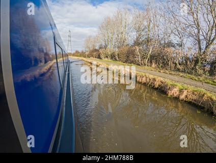 Blick auf die ländliche Landschaft Englands auf dem britischen Wasserstraßenkanal neben dem Schmalboot während des bewölkten bewölkten Tages Stockfoto