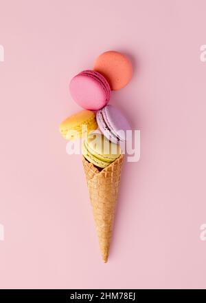 Bunte leckere Makronen oder Makronen in einem Eiswaffelkegel. Sommerliches Dessert-Konzept. Stockfoto