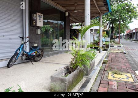 Motorrad links vor dem verlassenen Geschäft im Tanah Lot Tempel Bali. Aufgenommen Im Januar 2022. Stockfoto