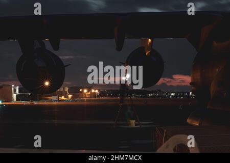 Ein taktischer Flugzeugbetreuer der US Air Force C-17 Globemaster III, der an das 204th Airlift Squadron angeschlossen ist, führt eine Motorenprüfung nach dem Flug auf der Marine Corps Air Station Futenma, Okinawa, Japan, am 27. Januar 2022 durch. Die C-17 trug zwei US Marine Corps AH-1Z viper Hubschrauber, die dem Marine Light Attack Helicopter Squadron 369 von Hawaii nach Okinawa zugewiesen waren, Japan als Teil eines Routineanstrengungen, Flugzeuge in und aus Japan zu drehen, um Wartungsprobleme zu verringern und die Interoperabilität mit den Schwerlastfähigkeiten der US-Luftwaffe zu trainieren. (USA Marine Corps Foto von PFC. Justin J. Marty) Stockfoto