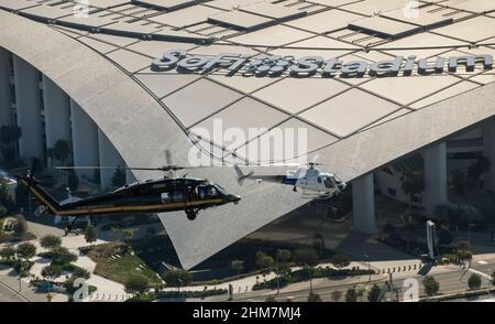 Ein US-amerikanischer Zoll- und Grenzschutz, Luft- und Marineoperationen UH-60 Black Hawk und ein AS350 A-Star passieren das SoFi-Stadion in Inglewood, Kalifornien, 6. Februar 2022. CBP-Foto von Glenn Fawcett Stockfoto