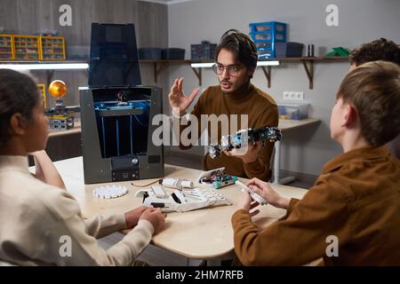 Porträt eines jungen Lehrers, der einer Gruppe von Kindern im Robotikunterricht in der Schule 3D Drucktechnologie vorführt Stockfoto