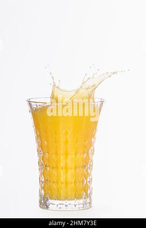 Nahaufnahme eines Glases mit spritzendem Orangensaft Stockfoto