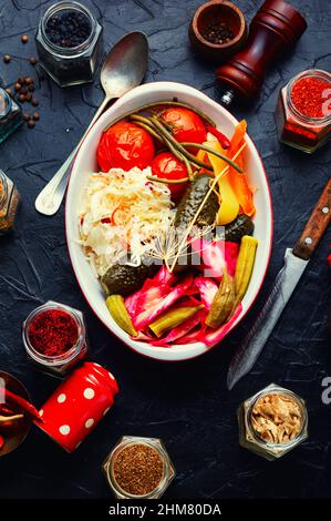 Eingelegte Gurken, Okra, Paprika, Tomaten und Sauerkraut in einer Schüssel. Appetitliche Gurken. Draufsicht Stockfoto