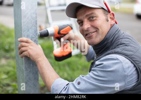 Man bohrt ein Metallstück, das in einen Schraubstock geklemmt ist Stockfoto