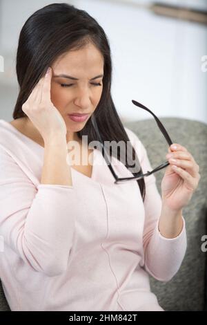 Unglückliche Frau leidet unter Kopfschmerzen zu Hause Stockfoto