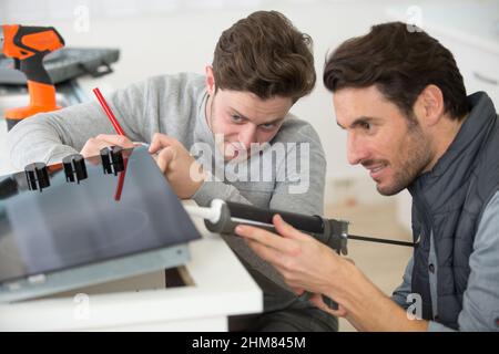 Zwei Männer installieren ein Kochfeld Stockfoto