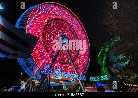 Panoramarad läuft im Dunkeln. Luna Park Attraktion. Langzeitbelichtung. Stockfoto