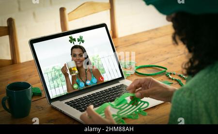 Kaukasische Frau, die eine Schamrock-Brille hält, während sie zu Hause einen Videoanruf auf dem Laptop führt Stockfoto