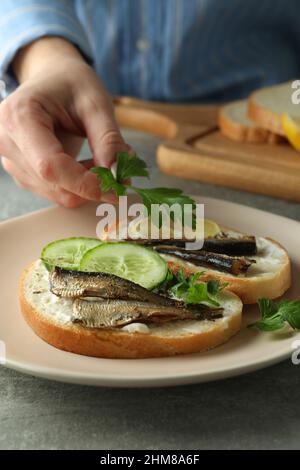 Konzept von leckeren Snacks mit Sandwiches mit Sprossen auf einem grauen strukturierten Tisch Stockfoto