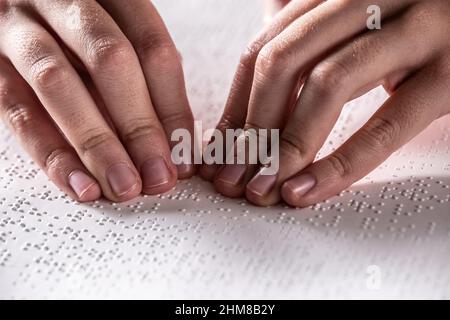 Detail der Hände des Kindes, die in Braille-Schrift lesen, Stockfoto