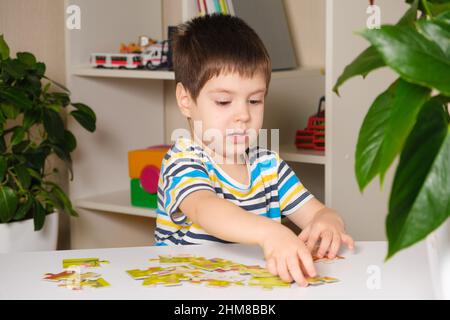 Ein Vorschulkinder spielt Puzzles, stellt ein Bild zusammen Stockfoto