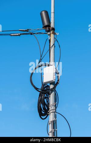 Kabelfernseherdung am Pfosten gegen blauen Himmel montiert Stockfoto