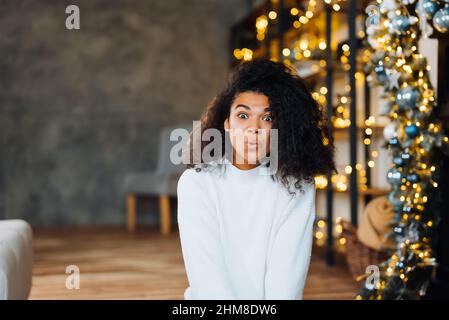 Schöne attraktive schöne überfröhliche Frau sitzt auf dem Boden Stockfoto