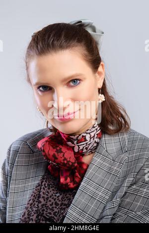 Nahaufnahme Porträt einer jungen erwachsenen Frau mit gesunder Haut auf grauem Hintergrund Stockfoto