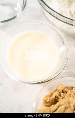 Gemessene Zutaten in Glasschüsseln zum Backen von Eiernang-Scones. Stockfoto