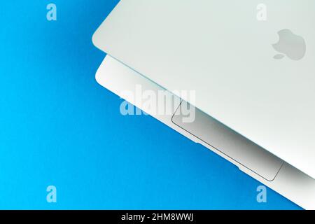 Apple Macbook Air mit M1 auf hellblauem Tischhintergrund. Business- und Bürokonzept, Draufsicht, Flat Lay Stockfoto