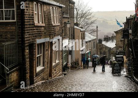 Haworth, Großbritannien: Main Street in Howarth, West Yorkshire, zieht Touristen aus der ganzen Welt wegen seiner Verbindungen zu den Bronte Sisters an. Stockfoto