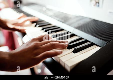 Klaviertasten entriegeln die Sprache der Seele. Zugeschnittene Aufnahme einer Frau, die zu Hause Musik auf einer Tastatur spielt. Stockfoto