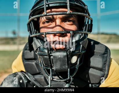 HES der schnellste Denker im Team. Aufnahme eines jungen Spielers, der beim Baseballspielen einen Catchers-Helm trägt. Stockfoto