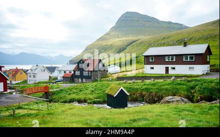 Malerischer Blick auf das Dorf Gjogv mit typisch bunten Häusern auf der Insel Eysturoy, Färöer-Inseln, Dänemark. Stockfoto