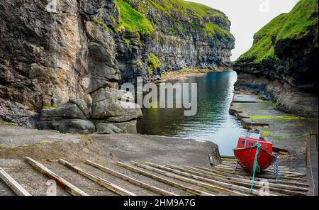 Holzboot im Naturhafen von Gjodv Dorf. Insel Eysturoy. Atlantik, Färöer, Königreich Dänemark, Europa. Stockfoto