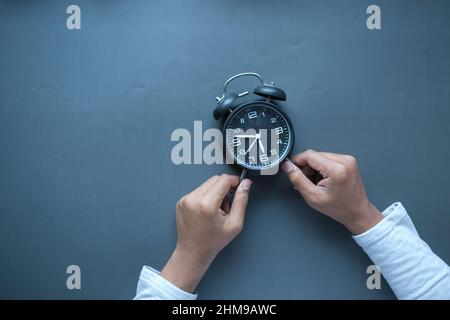 Person Hand hält Wecker schwarzen Hintergrund , Stockfoto