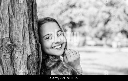 Immer lächelnd. Glückliches Mädchen lächeln am Baum auf der Sommerlandschaft. Zahngesundheit. Mundpflegeprodukte. Zahnpflege. Kinderzahnmedizin. Mundhygiene beachten Stockfoto