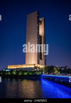 Bahrains Four Seasons Hotel beleuchtet in der Nacht und zeigt den blauen Farbton von der Verbindungsbrücke zur Insel, auf der sich das Hotel befindet. Stockfoto