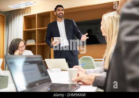Junger Geschäftsmann als Coach und Team während der Motivationstrainings im Konferenzraum im Büro Stockfoto