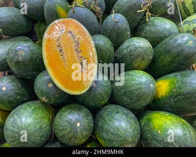 Haufen ovaler gelber Wassermelone auf dem Obstmarkt Stockfoto