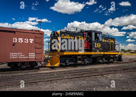 Antonito, CO - 23. August 2021: Cumbres und Toltec 19 General Electric 50-Tonnen-Diesel-Elektroschaltlokomotive unterstützt einen Zug durch den Hof Stockfoto