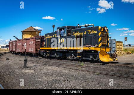 Antonito, CO - 23. August 2021: Cumbres und Toltec 19 General Electric 50-Tonnen-Diesel-Elektroschaltlokomotive unterstützt einen Zug durch den Hof Stockfoto